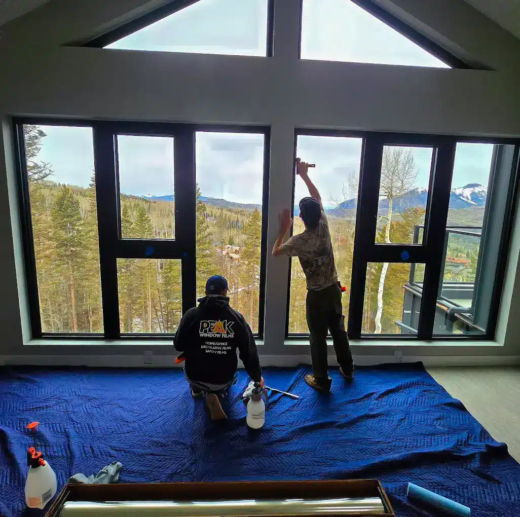 home-window-films-install-telluride-co Peak Window Tinting crew installing residential window tint on large living room windows with mountain views in Telluride, Colorado.